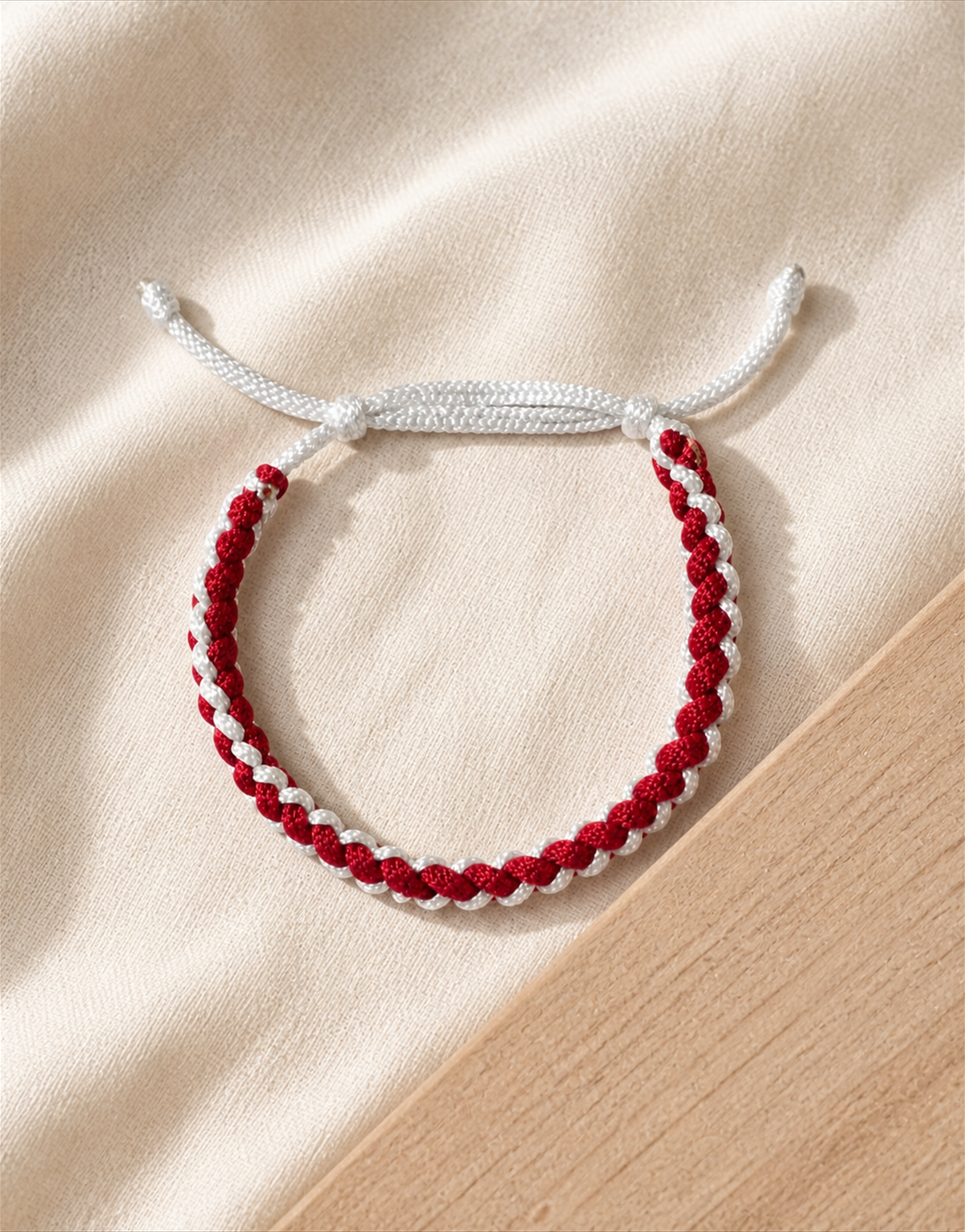 Anaar red and white bracelet on linen over wood