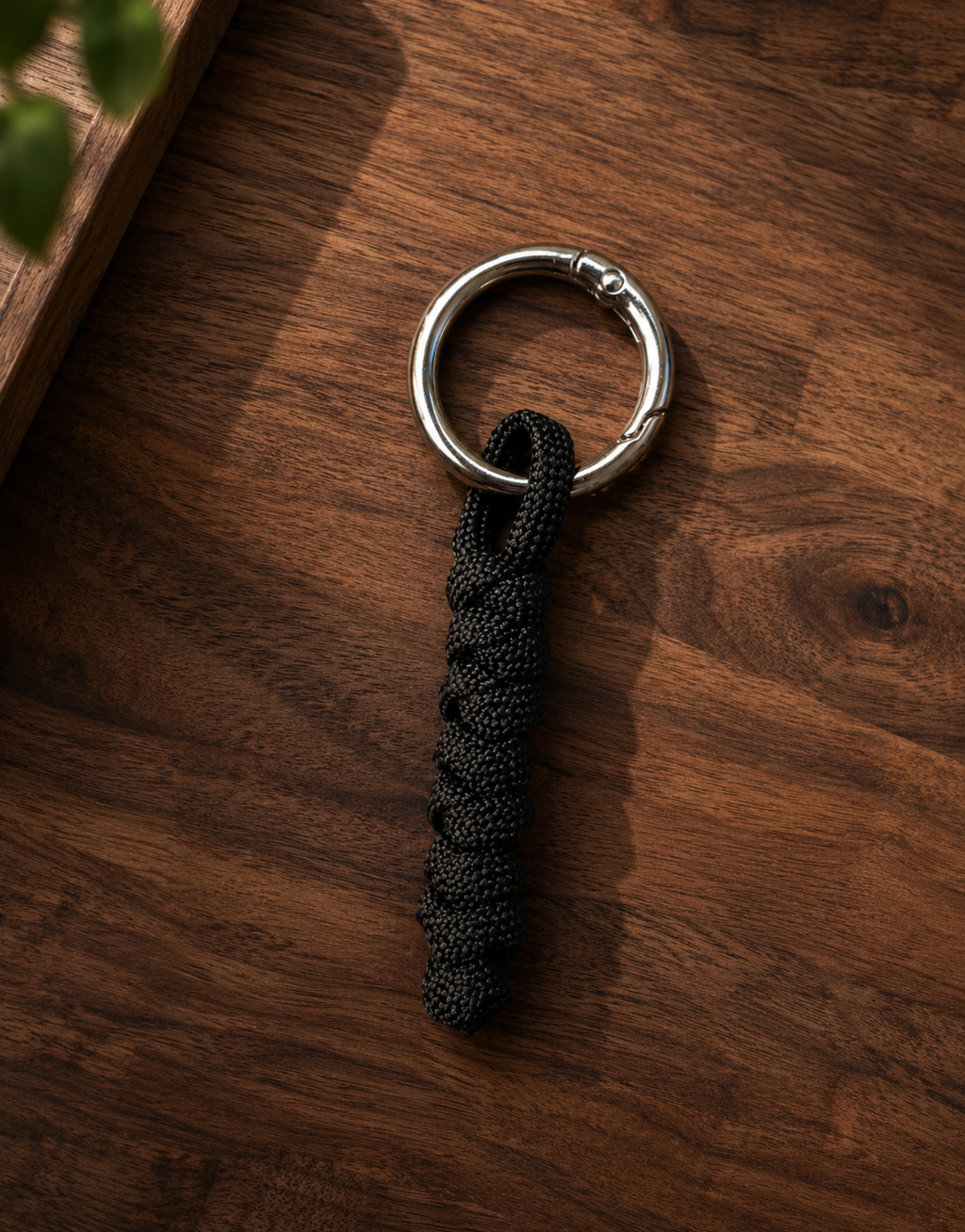Lahar black paracord keychain on a walnut wood surface