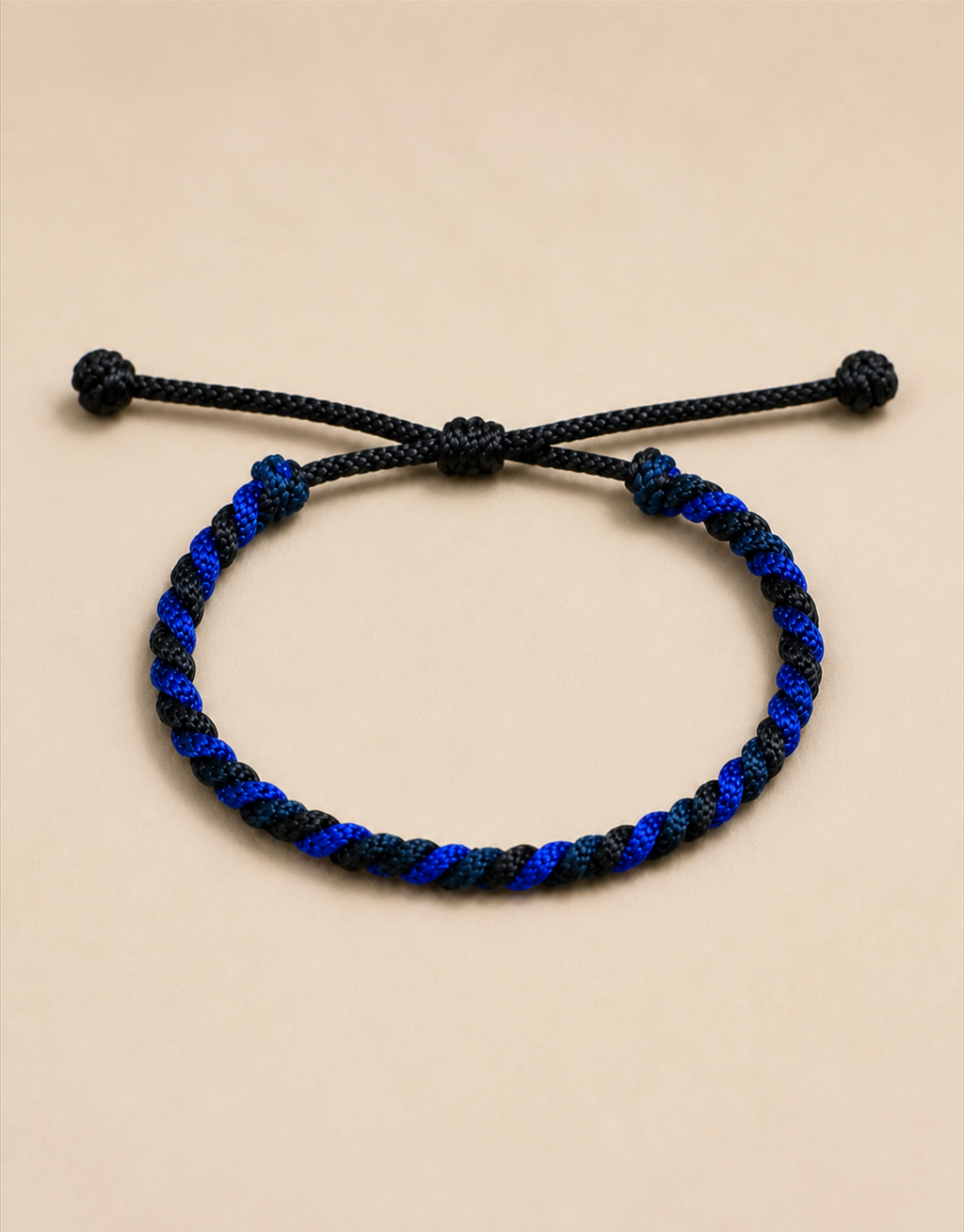 Neelam blue and black cord bracelet on a beige background