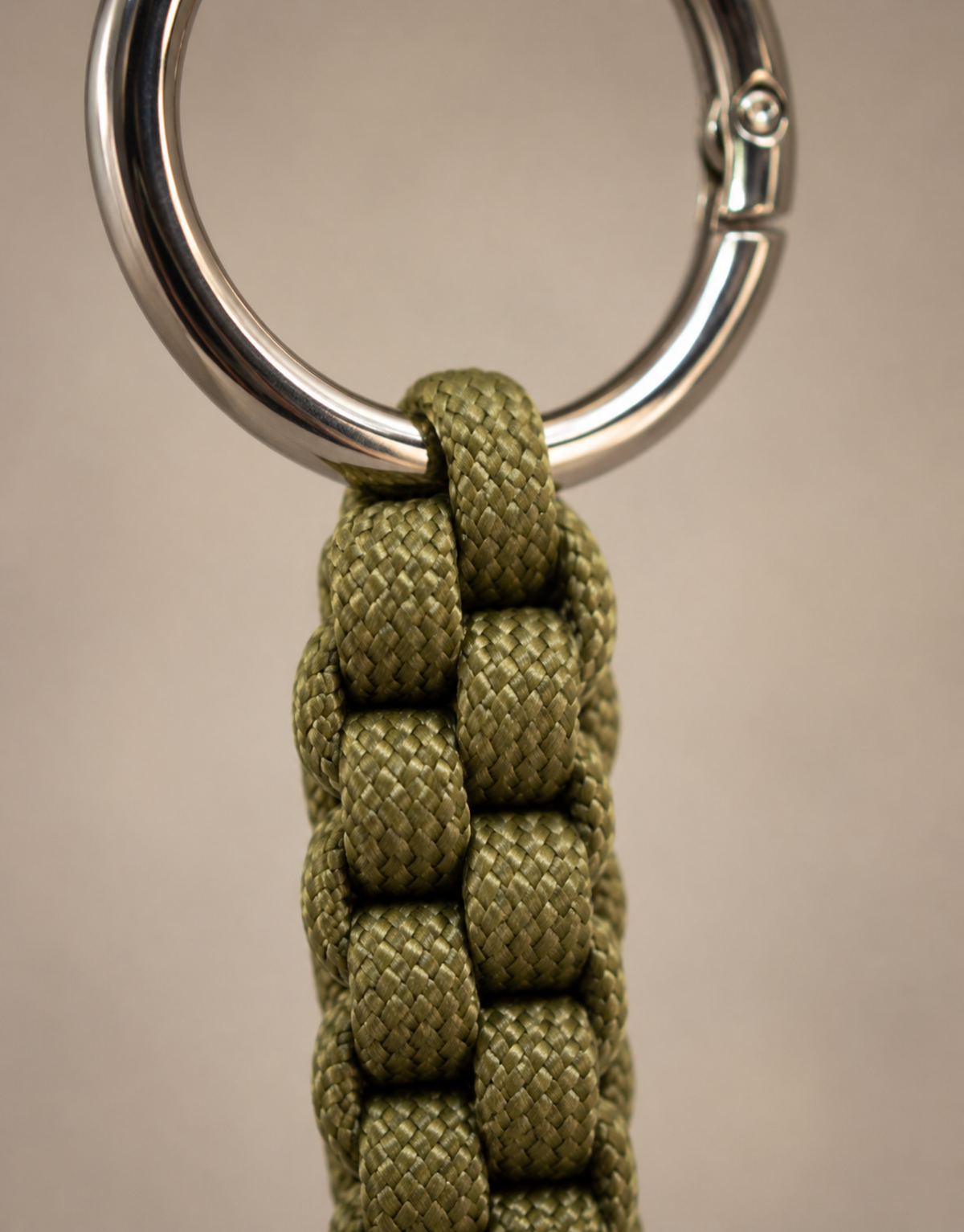 Close-up of the olive box weave and stainless steel ring on the Saf paracord keychain