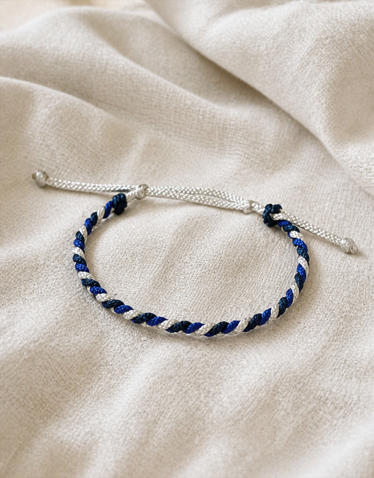 Sadeem blue, white and black macrame bracelet on linen