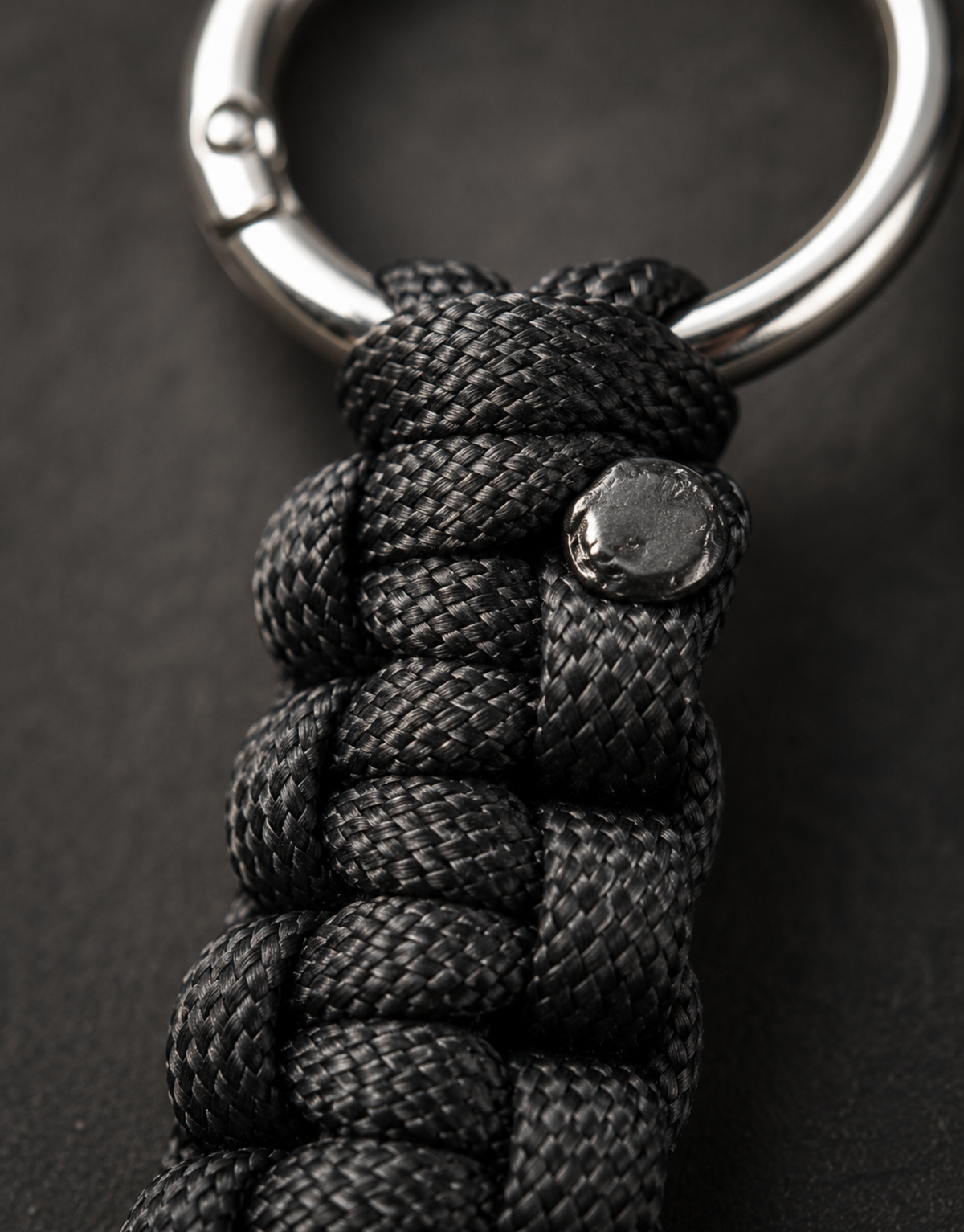 Macro of the black cobra weave and steel ring on the Naag paracord keychain