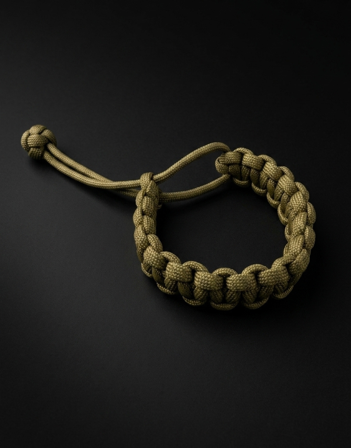 Zeytoon olive cobra paracord bracelet with the loop open, dark background