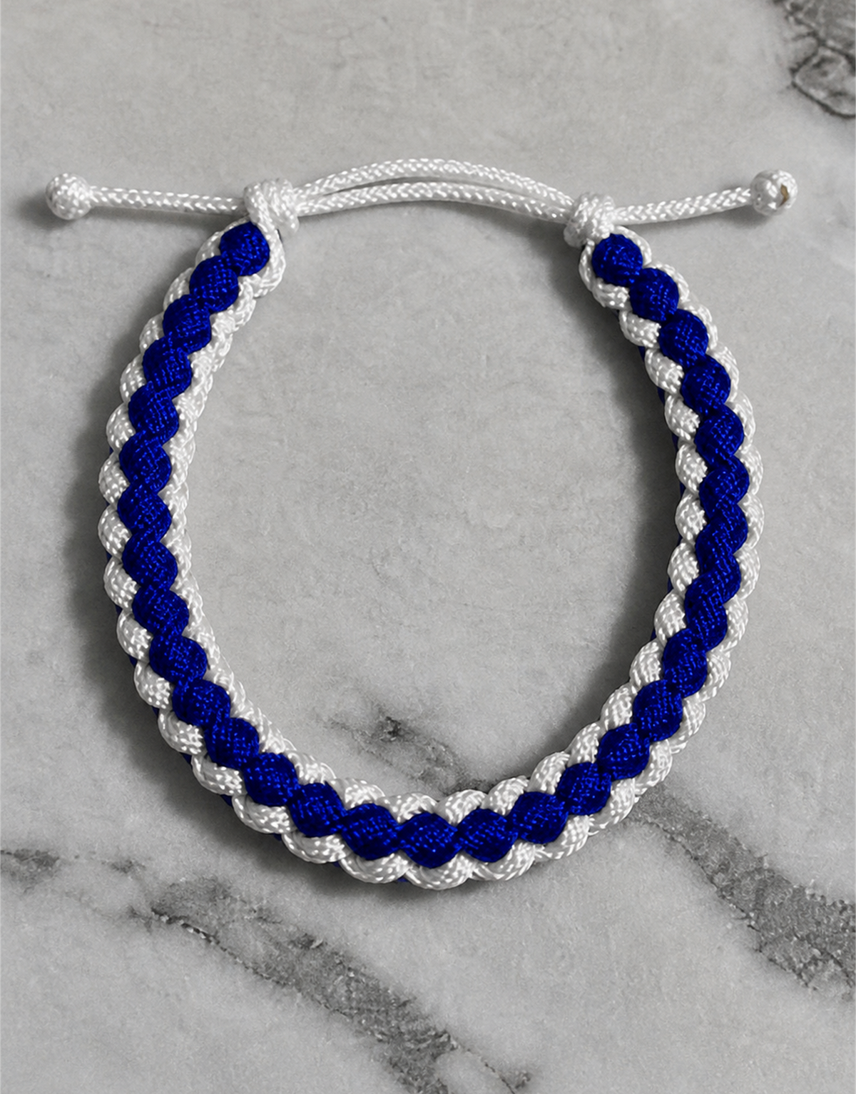 Close-up of the Samawi blue and white macrame bracelet on marble
