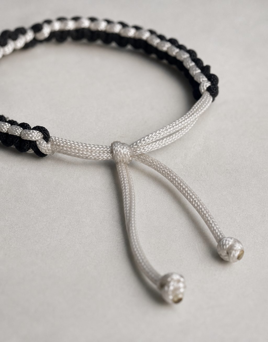 Sliding cord closure on the Shatranj black and white macrame bracelet