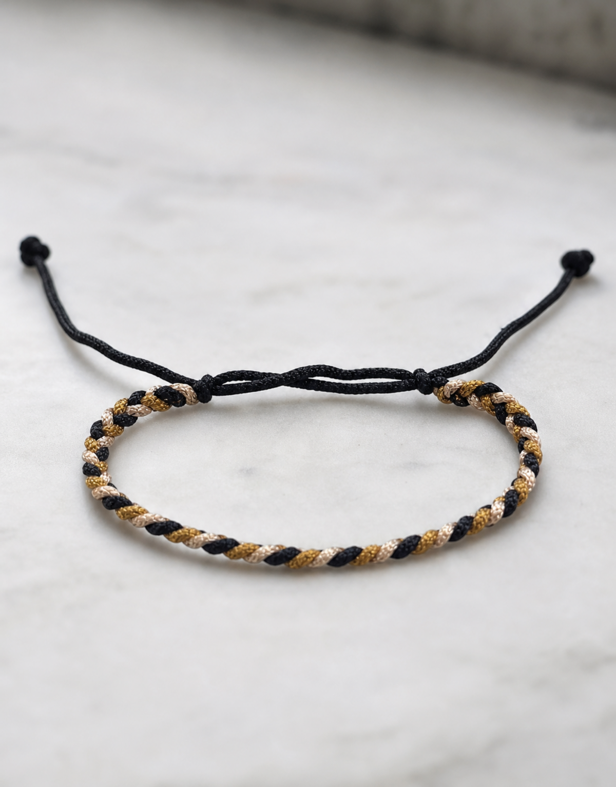 Zari gold macrame bracelet on white marble