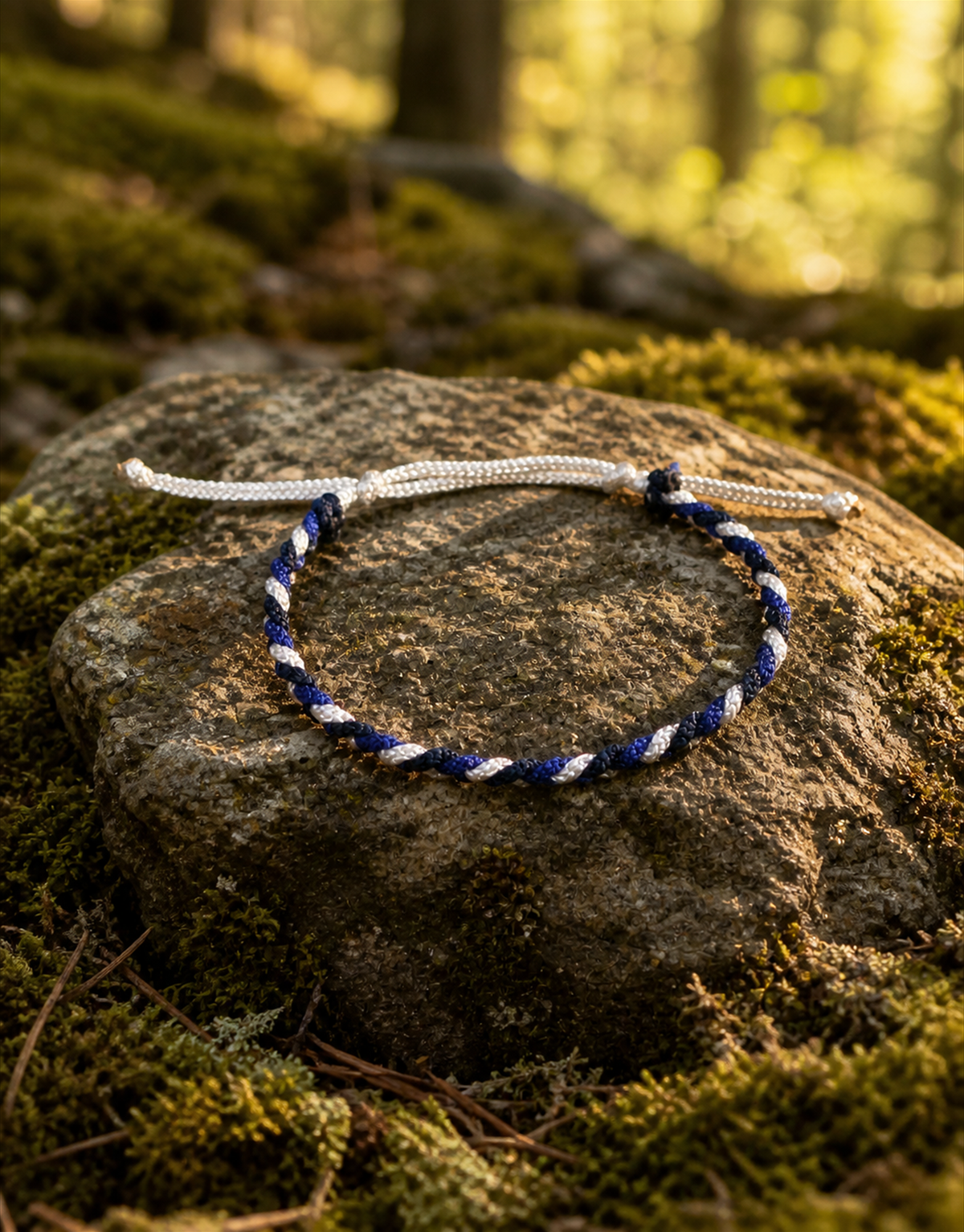 Sadeem blue and white bracelet on a mossy rock in a forest