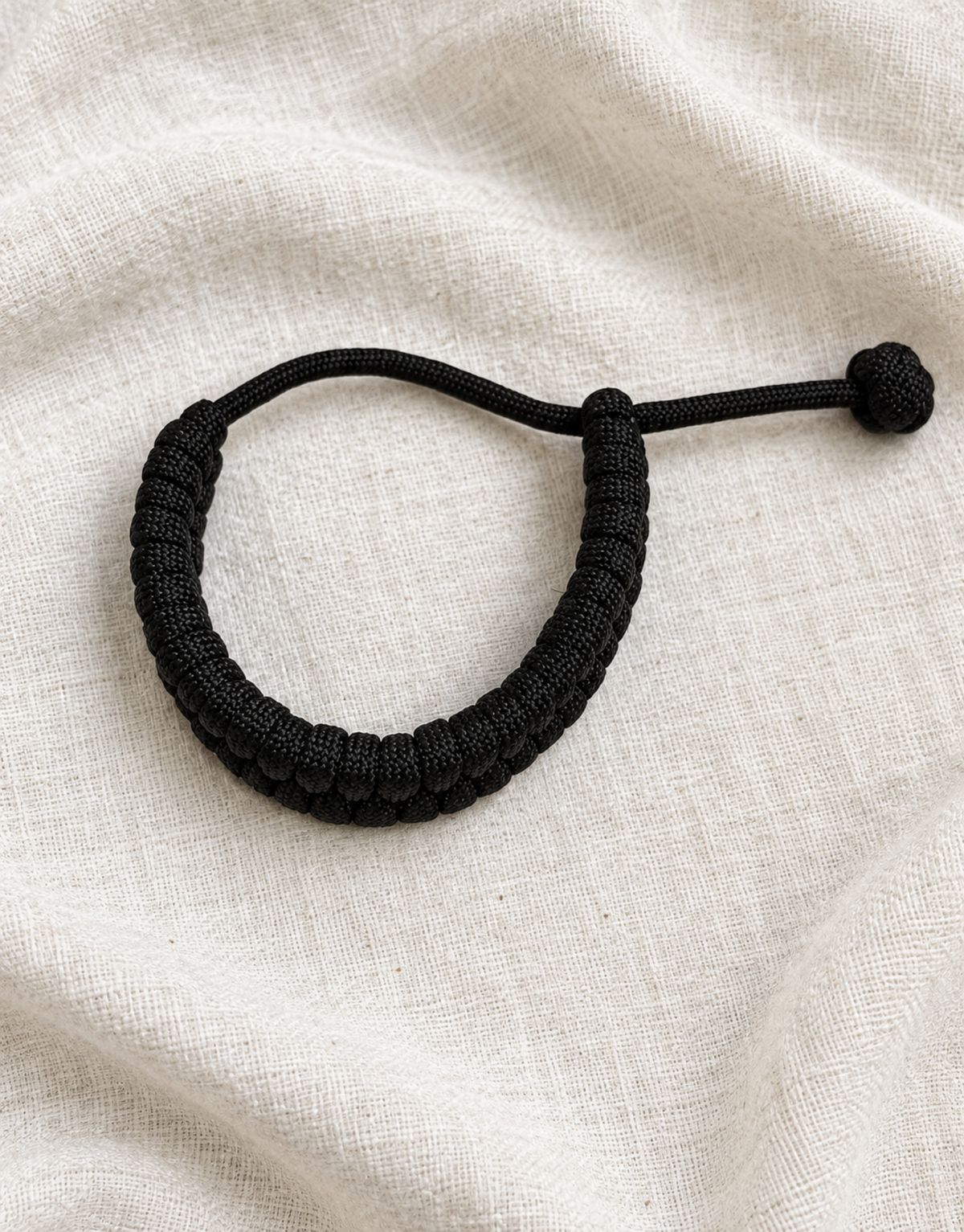 Juft black paracord bracelet on linen