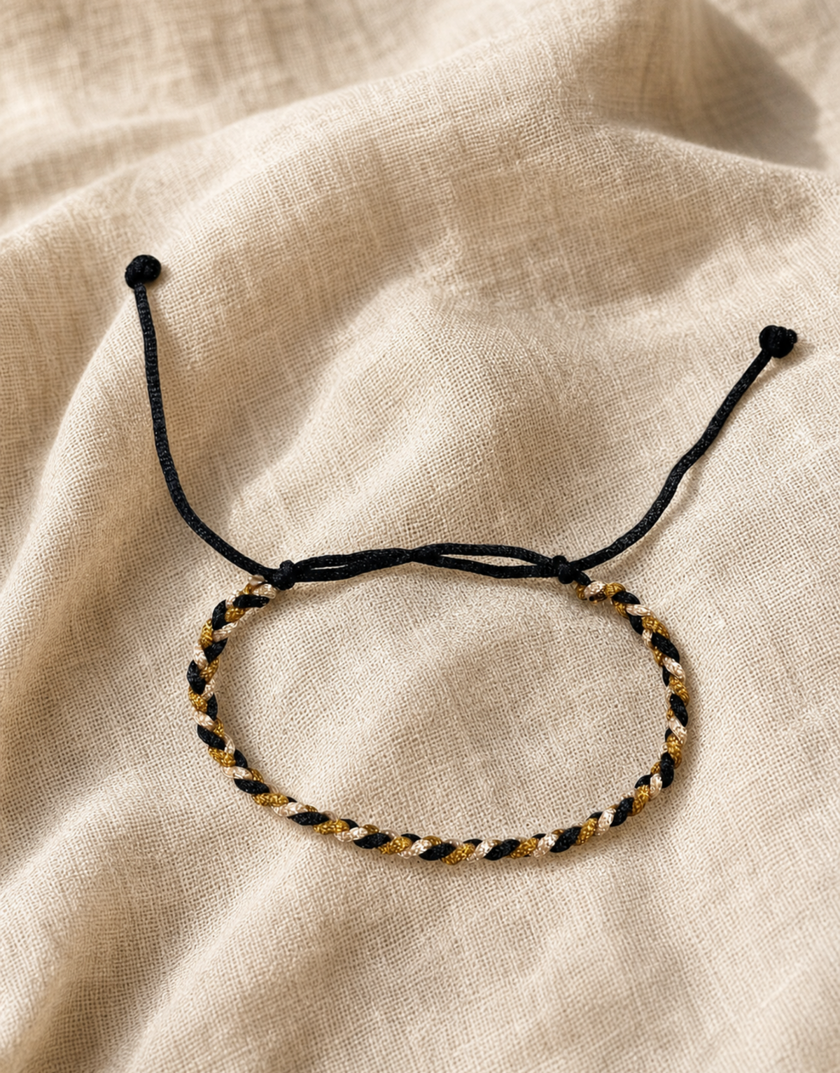 Zari gold and cream macrame bracelet on linen fabric