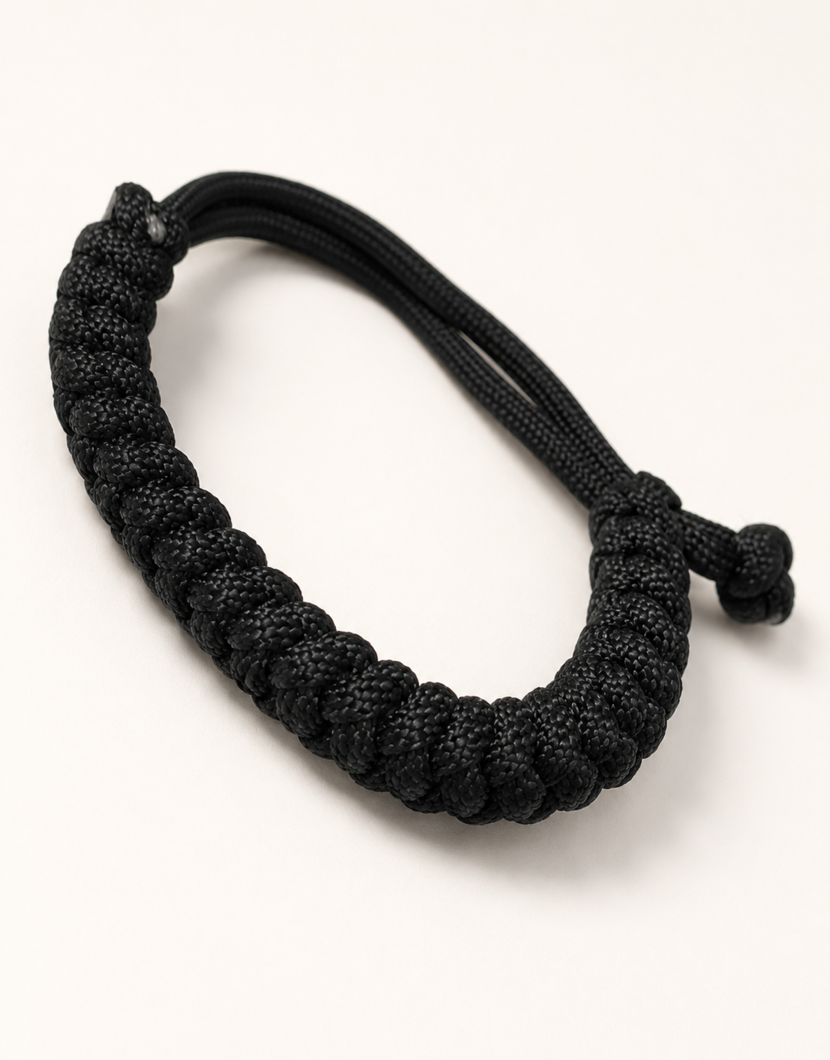 Pech black spiral paracord bracelet on a cream background