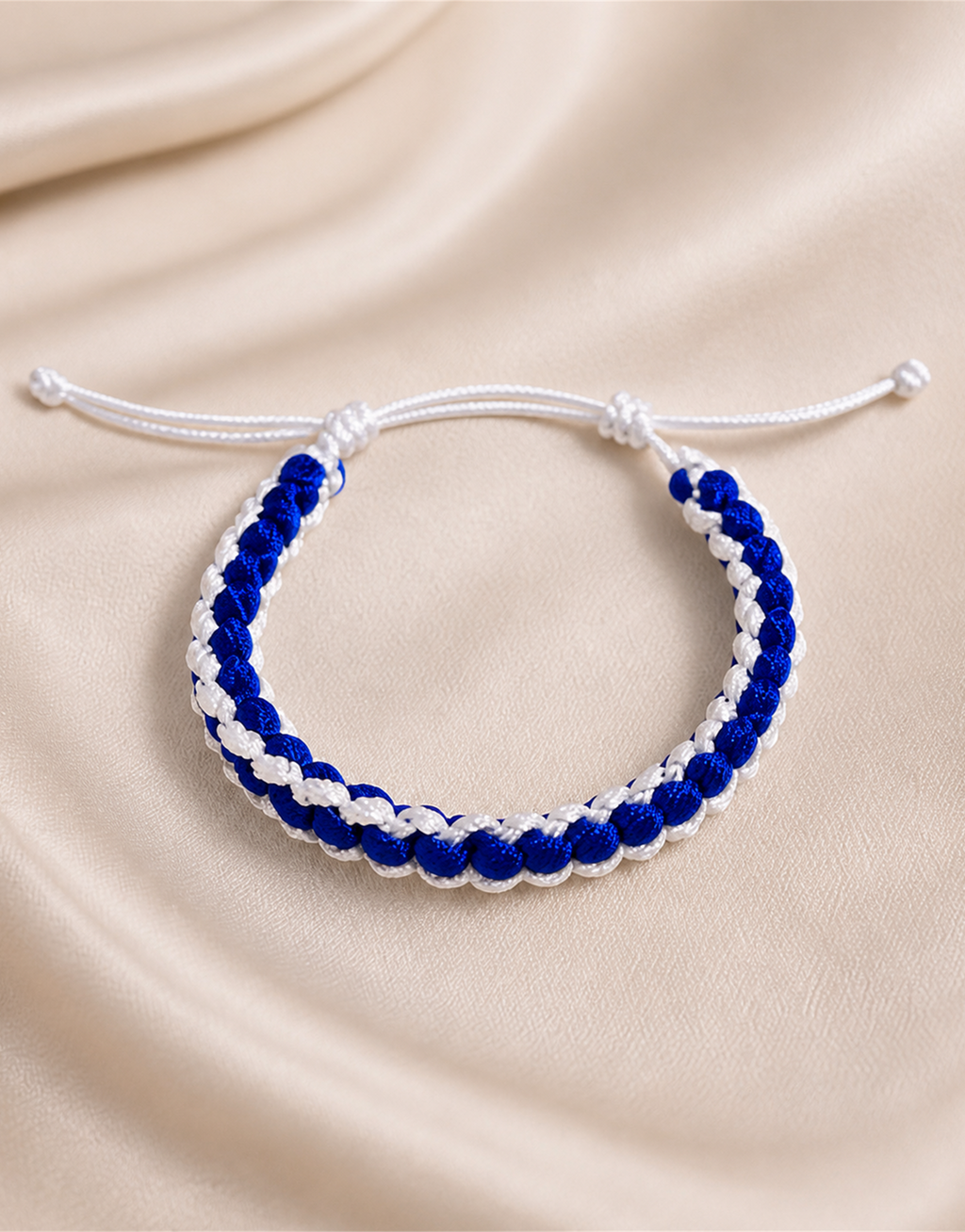 Samawi blue and white macrame bracelet on cream fabric