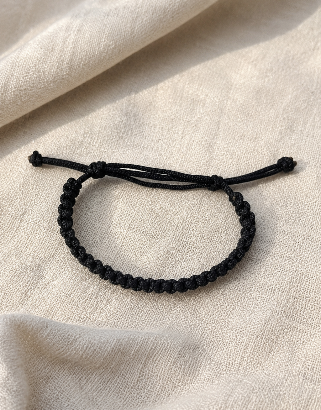 Khayt black macrame cord bracelet on linen