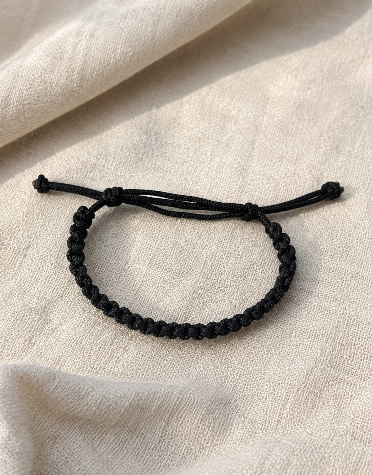 Khayt black macrame cord bracelet on linen