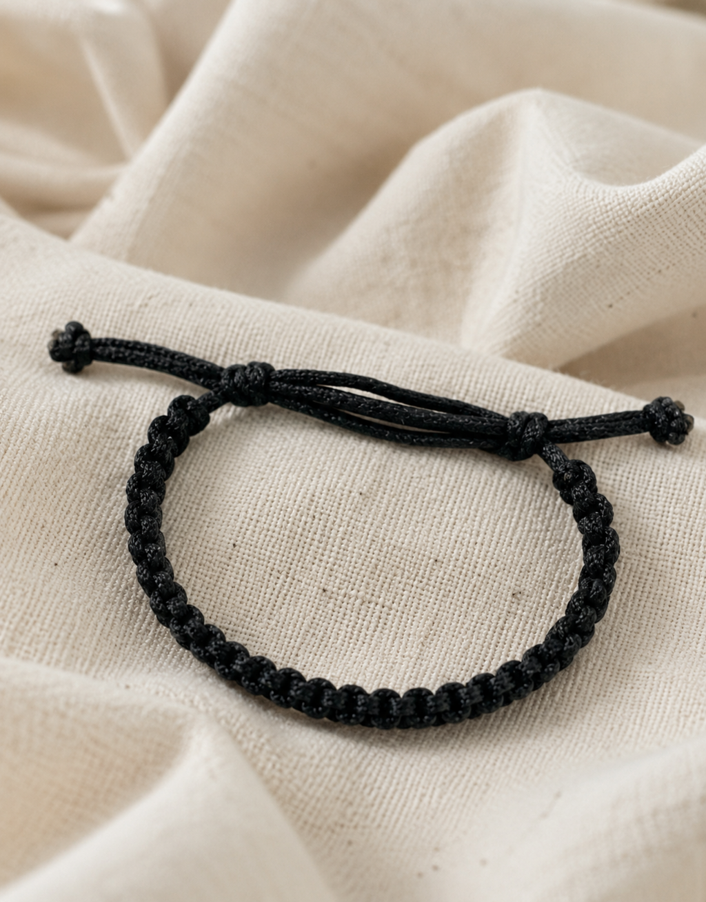 Khayt black macrame bracelet on cream fabric