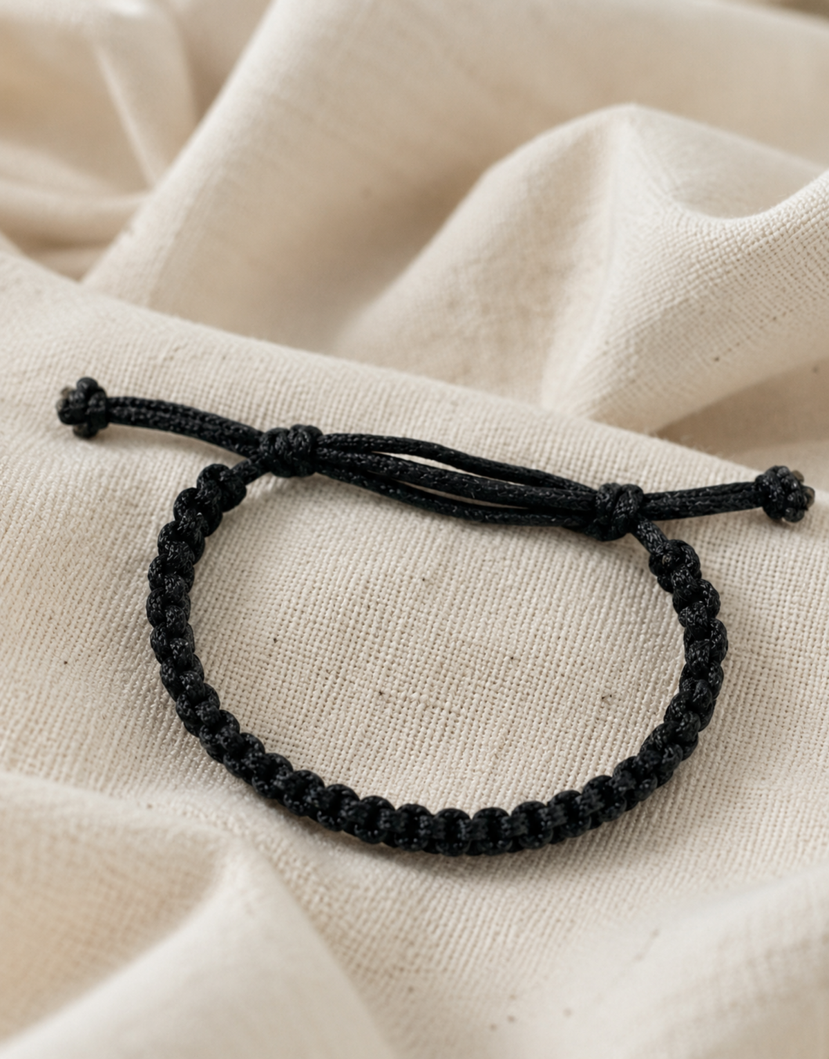 Khayt black macrame bracelet on cream fabric