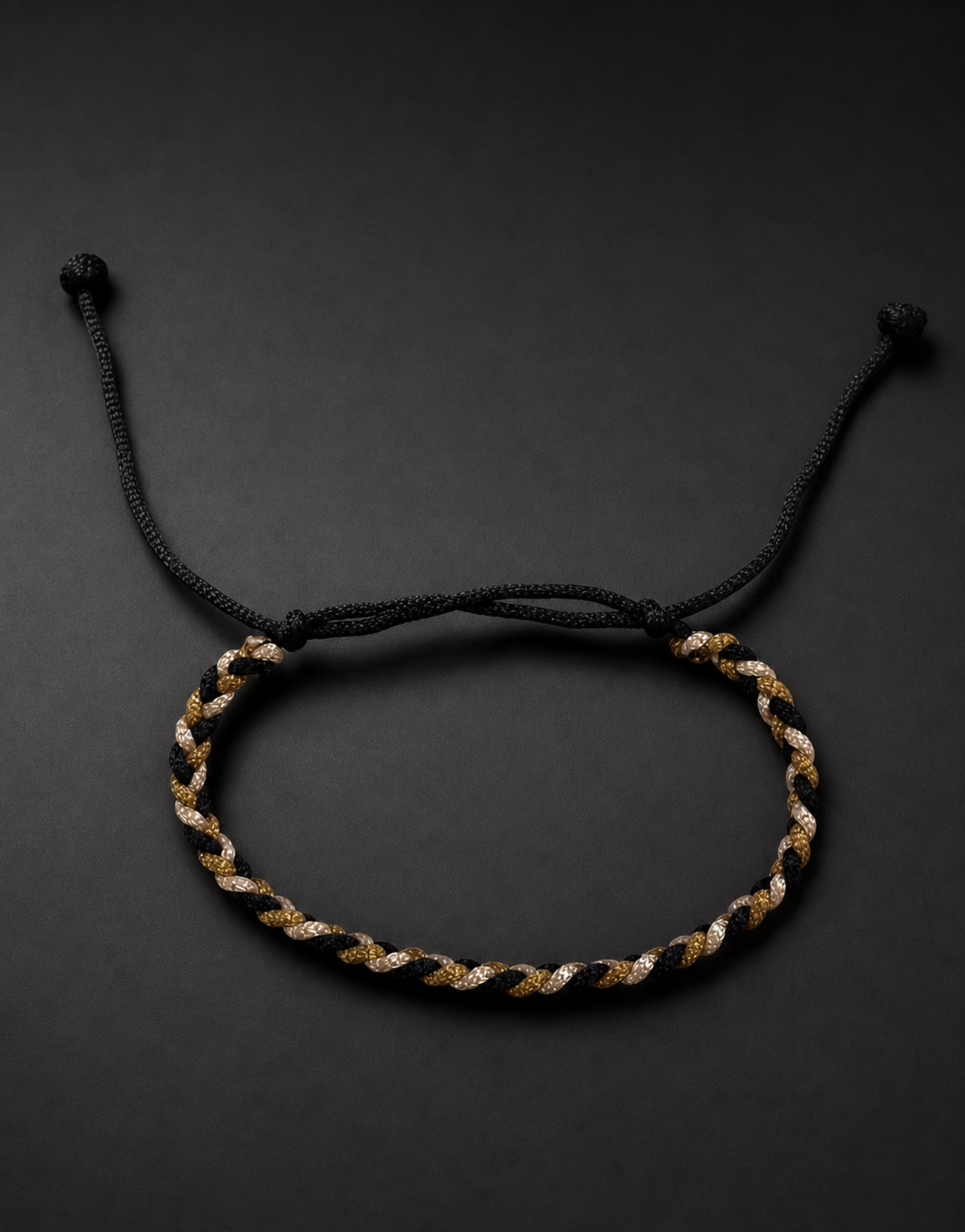 Zari black, gold and cream bracelet on a black background