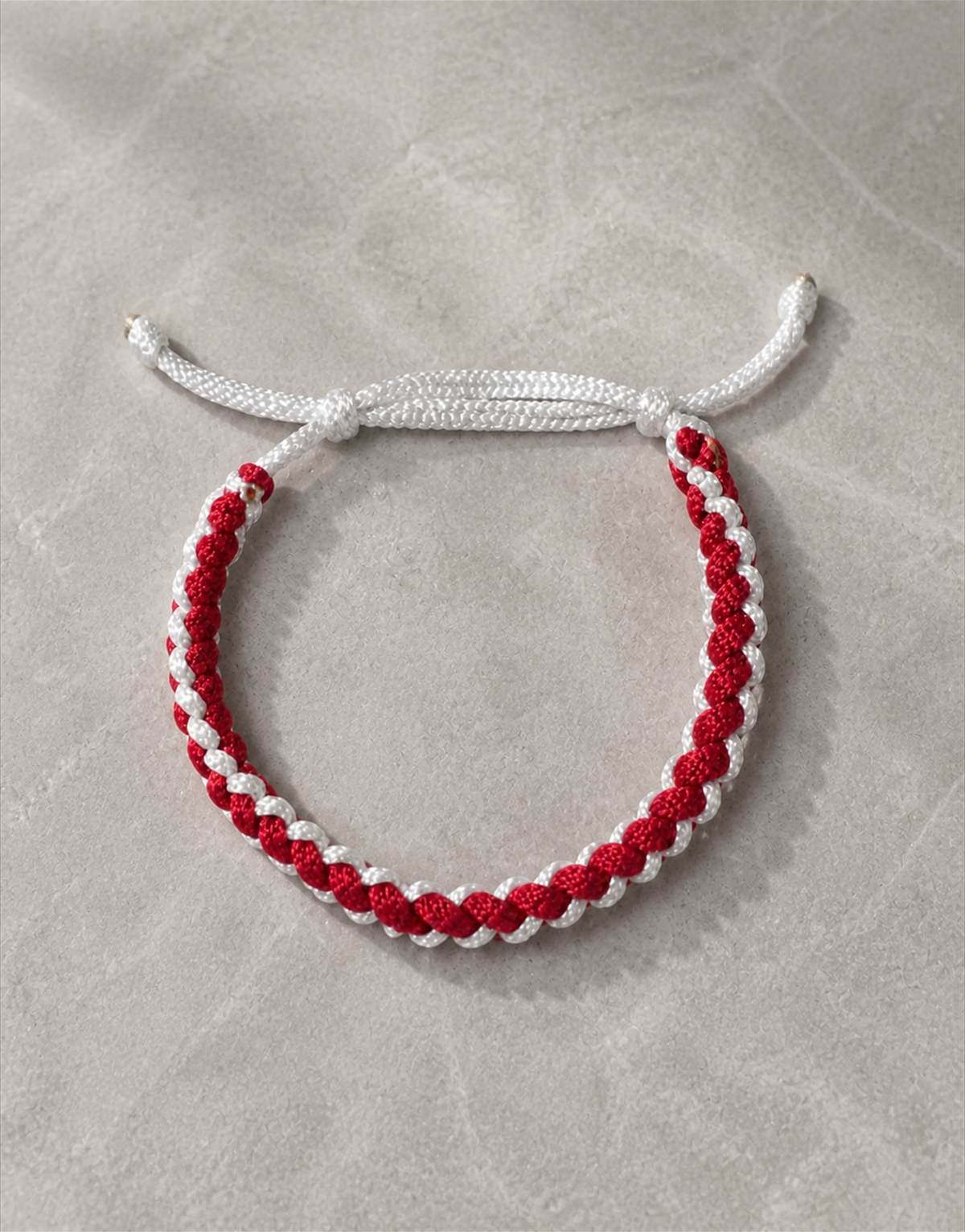 Anaar red and white bracelet on grey fabric
