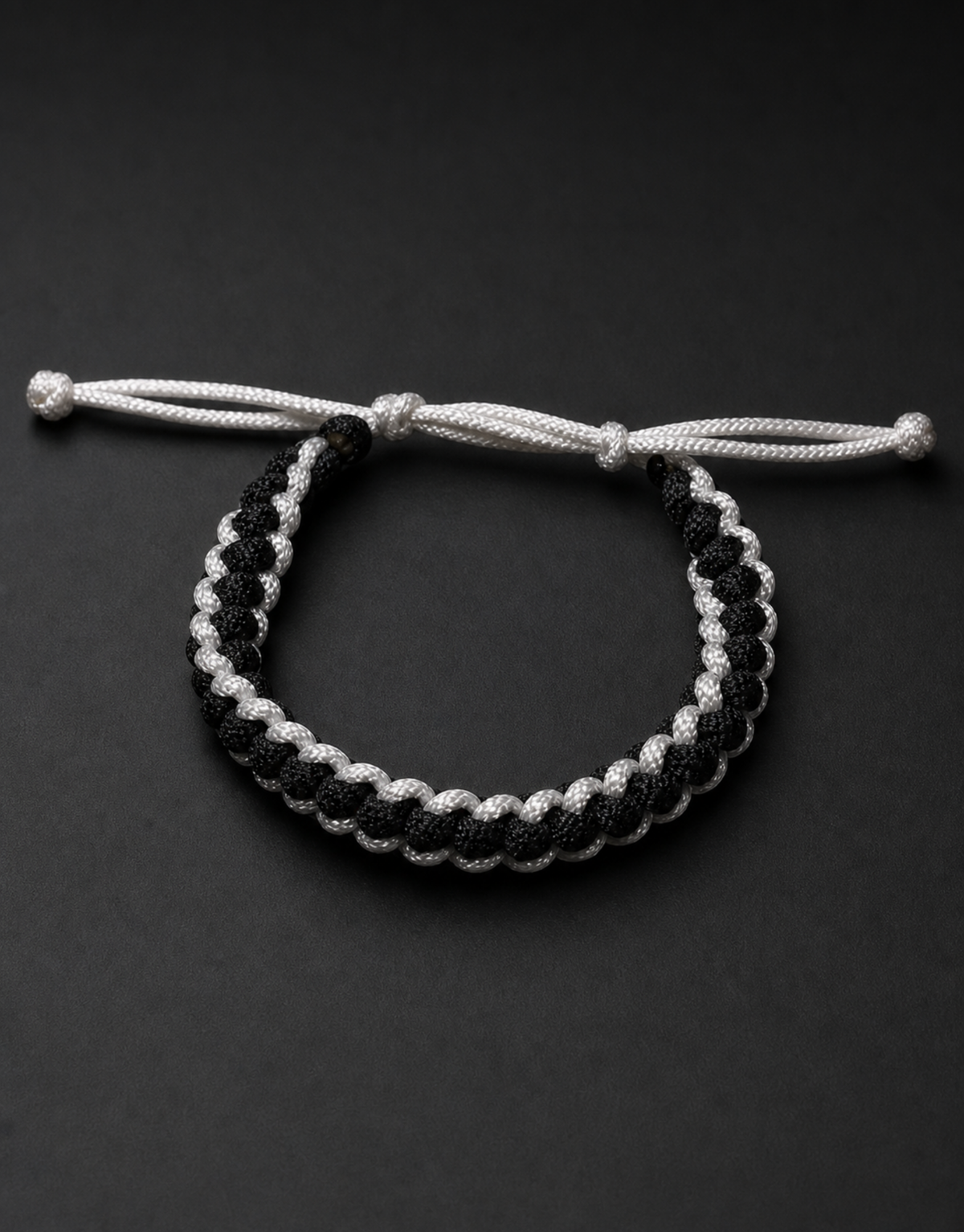 Shatranj black and white macrame bracelet on a black background