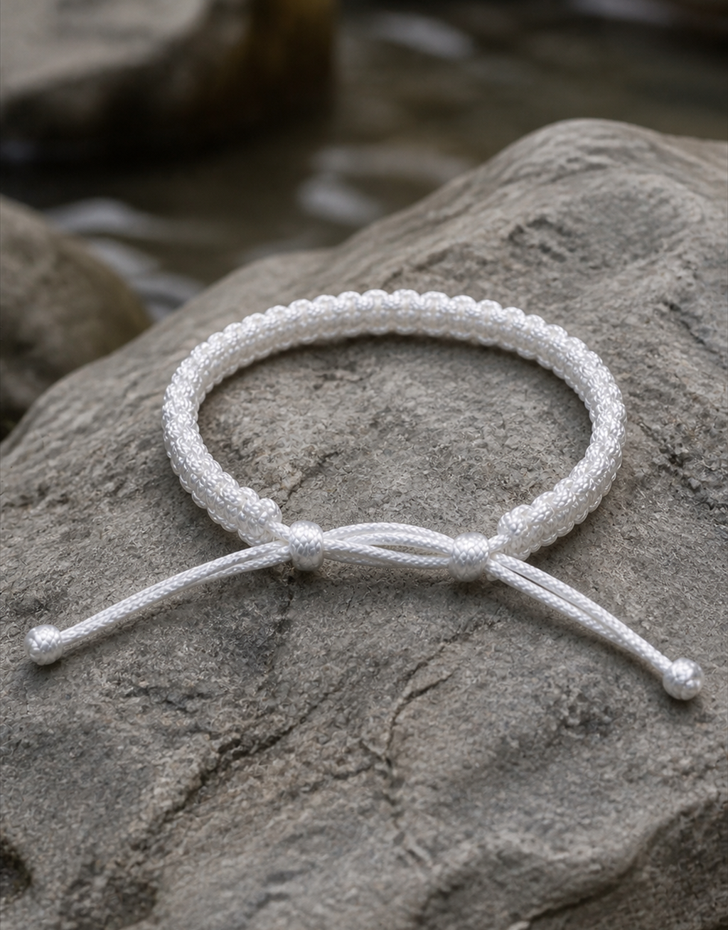 Durr white macrame bracelet on a rock by water