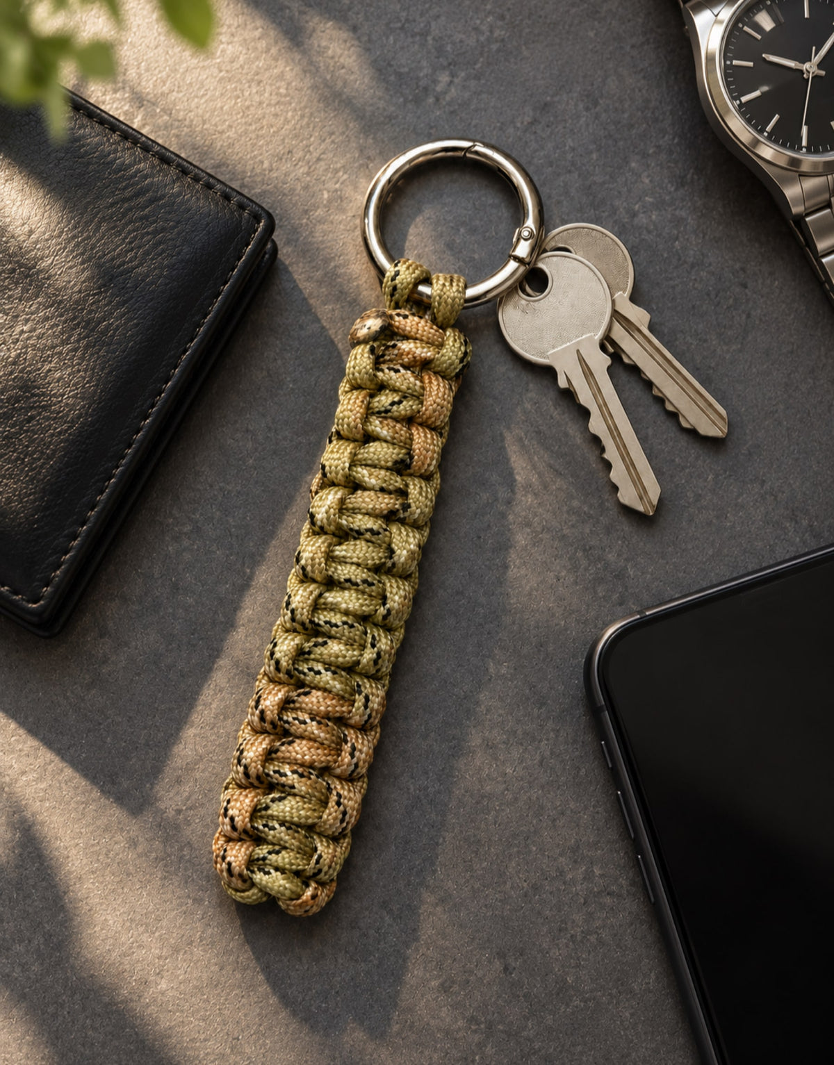 Naag camo paracord keychain on a desk with everyday carry gear
